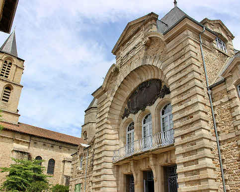 Façade d'un bâtiment historique en pierre avec balcon et clocher, agence DiagEssentiel