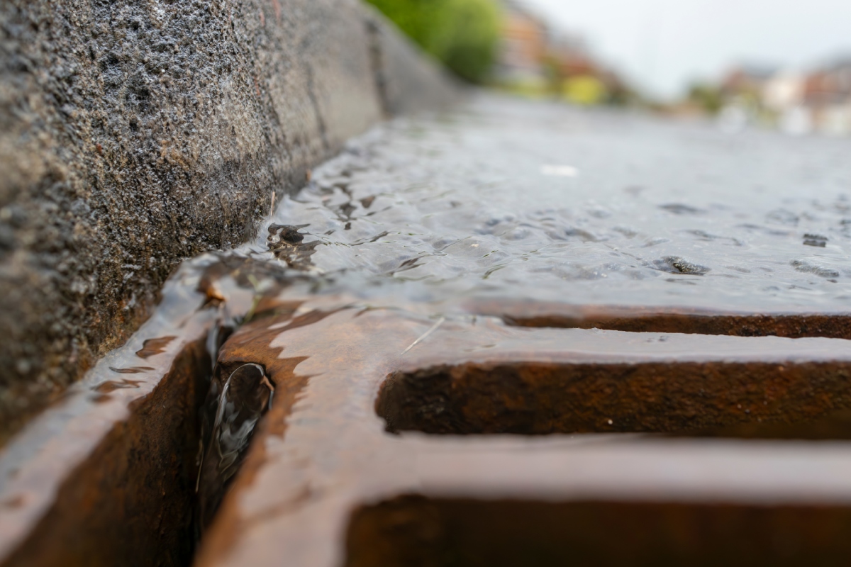Eaux de pluie s'écoulant dans une grille d'égout, risques naturels ERP